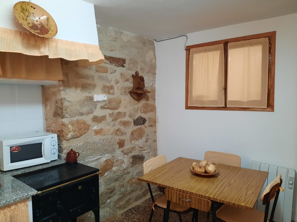 Cocina-comedor con pared de piedra – Apartamento 1